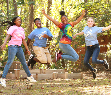 Four girls in Pace t-shirts jumping into the air
